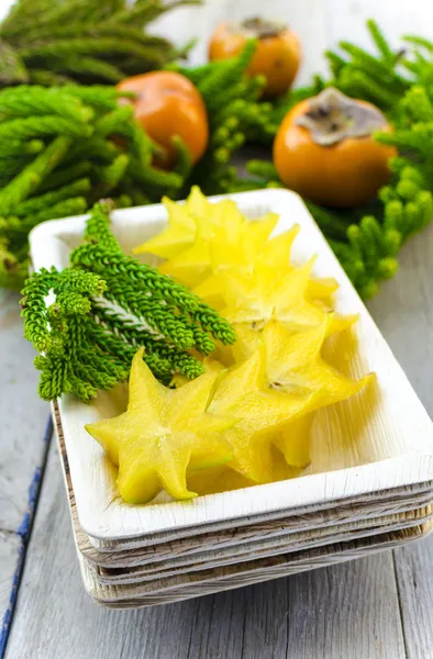 Carambola (starfruit), persimmons and araucaria — Stock Photo, Image