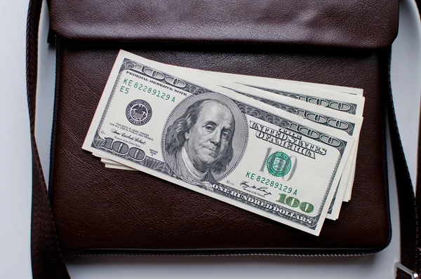 100 dollar bills and a leather bag — Stock Photo, Image