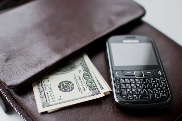 Denominations of money in the leather pouch and phone — Stock Photo, Image