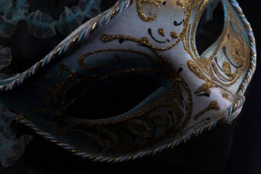 Siyah arka planda altın kaplamalı mavi ve gümüş Venedik maskesi