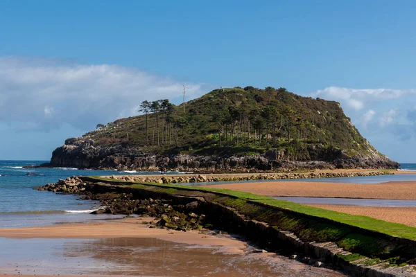 Lekeitio adası gelgitte güneşli bir günde mavi gökyüzü ve deniz