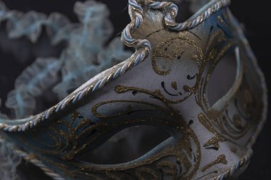 Siyah arka planda altın kaplamalı mavi ve gümüş Venedik maskesi