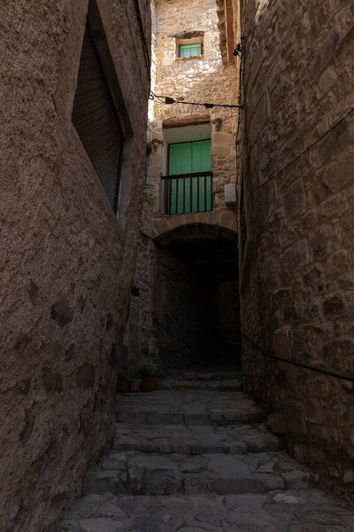Narrow alley with an arch and stairs in the town of Guimera