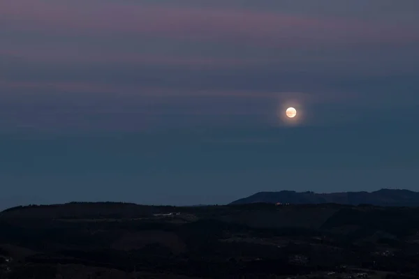 full moon in the blue hour over the mountains of the Basque country
