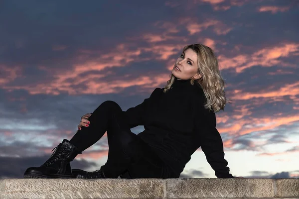 Retrato Mulher Loira Vestida Preto Pôr Sol Sentado Uma Parede — Fotografia de Stock