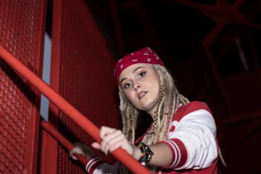 Rastalı kadın merdivenlerden yukarı çıkıyor.