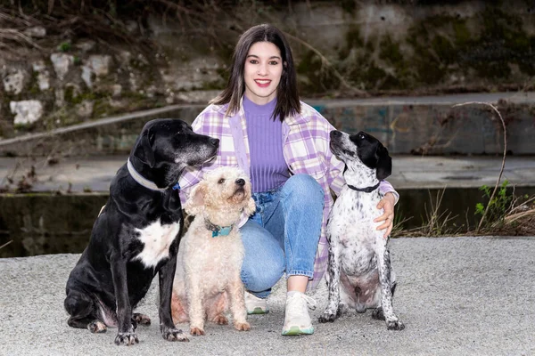 woman posing with three adopted dogs. dog adoption