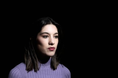 Siyah arka planda esmer bir kadın.