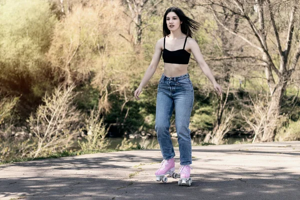 Brunette Woman Jeans Sports Bra Skating Stock Image