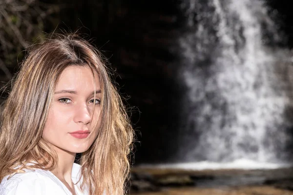 portrait of a blonde woman in a waterfall in the basque country