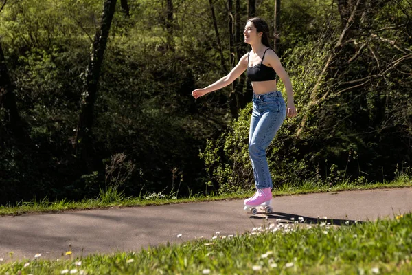 Donna Bruna Pattinaggio Nel Parco Con Pattini Rotelle Rosa — Foto Stock