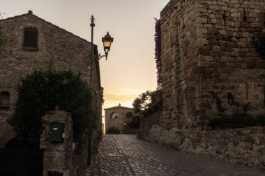 Bir yaz günü gün batımında Ortaçağ ahbapları 'nın taş caddesinde