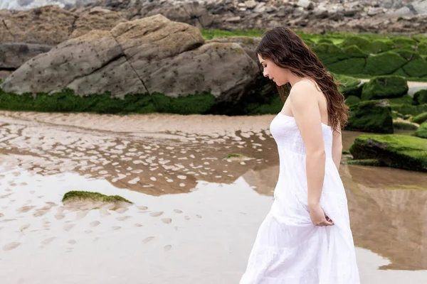 白いドレスを着た女性がビーチを歩いていて — ストック写真
