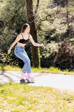 Parkta pembe patenli esmer kadın.