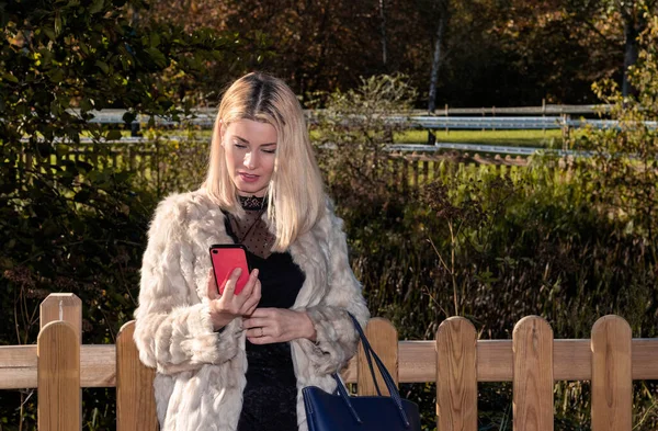 Blonde Woman Looking Red Mobile Park Dressed White Coat — Stock Photo, Image