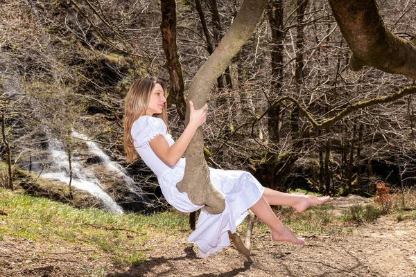 Young Blonde Woman White Dress Sitting Branch Forest Swinging — Stock Photo, Image