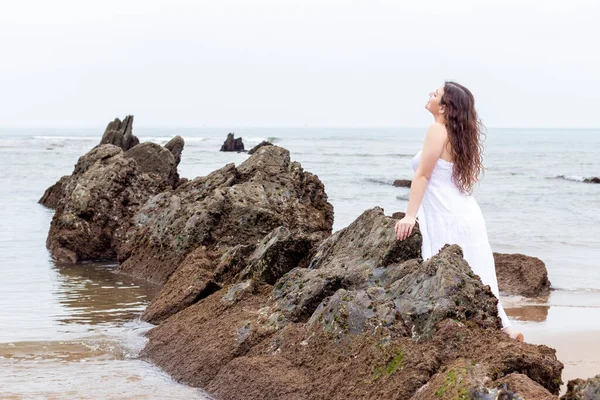 Jovem Morena Mulher Inclinada Uma Rocha Praia Vestido Branco — Fotografia de Stock