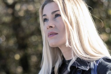 Parktaki kendine güvenen güzel sarışın kadının portresi.