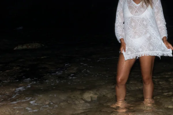 夜に海の水に触れるセクシーで若い認識できない女性 岩のあるビーチの女の子 夏休みと海を楽しむ女性 — ストック写真