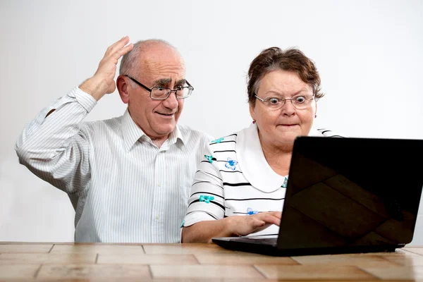 Пожилая пара с ноутбуком — стоковое фото
