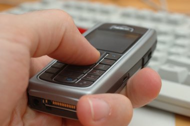 bir elinde cep telefonu