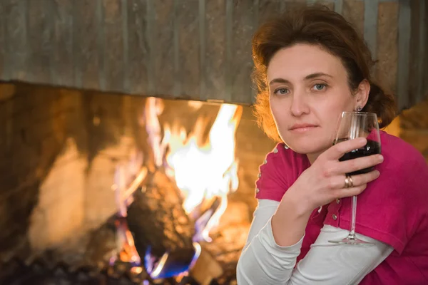 Lady, wine, fireplace — Stock Photo, Image
