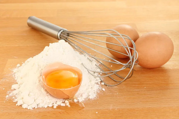 Eggs and whisk — Stock Photo, Image