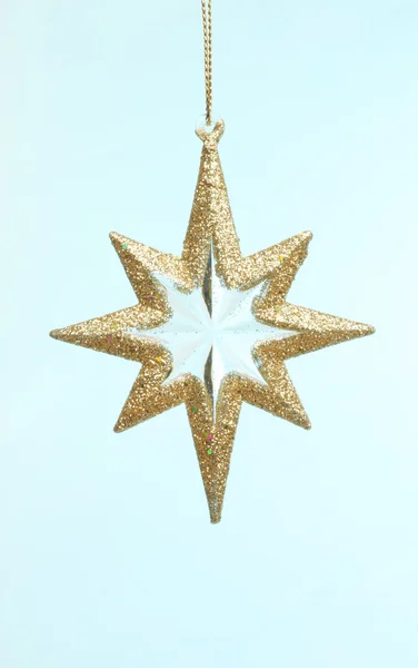 Gold star ornament against blue