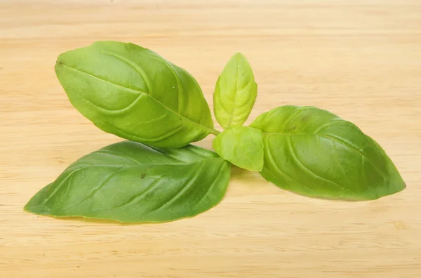 Foglie di basilico su una tavola di legno — Foto Stock