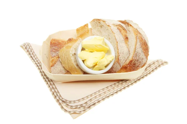 Crusty bröd och smör i en korg — Stockfoto
