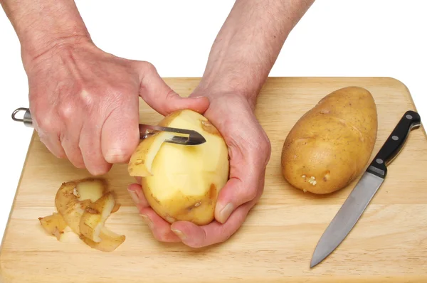 Händer peeling en potatis — Stockfoto