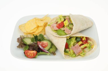 Domuz pastırması, marul ve domates paketleri. Salata ve patates cipsi ile birlikte. Beyaza karşı izole bir tabakta.