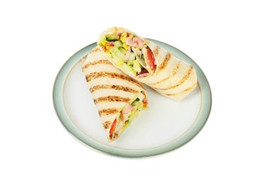 Izgara tortilla sarıp beyaza karşı izole edilmiş bir tabağa koyar.