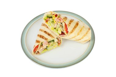 İki pastırma, marul ve domates ızgara tortilla paketleri beyaza karşı izole bir tabakta.