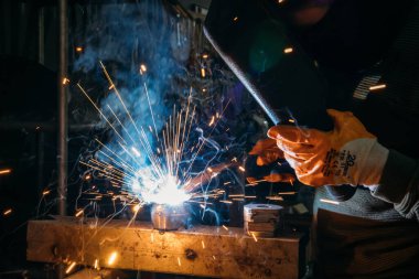 Industrial welder worker welding steel or iron in a factory