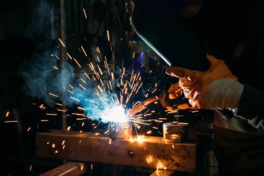 Industrial welder worker welding steel or iron in a factory