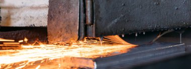 Metalworking industry machine grinder with sparks and fire in a factory.