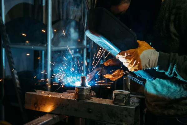 Industrial welder worker welding steel or iron in a factory