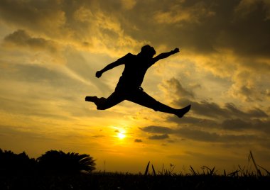 gün batımı sırasında atlama adam silüeti