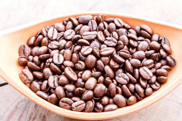 Koffie bean in kom op grunge hout achtergrond — Stockfoto