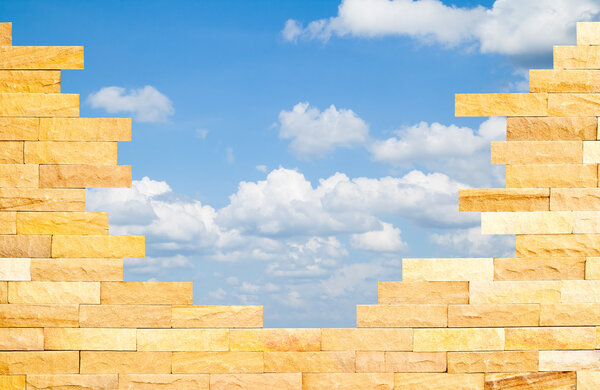 Стена Брика с красивым синим небом позади
