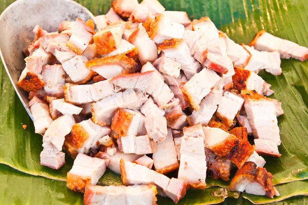 Grilled suckling pig cut as small piece on banana leaved