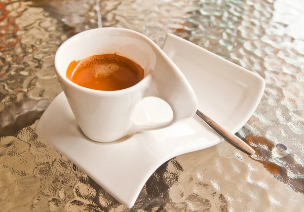Taza de café sobre mesa de vidrio — Foto de Stock