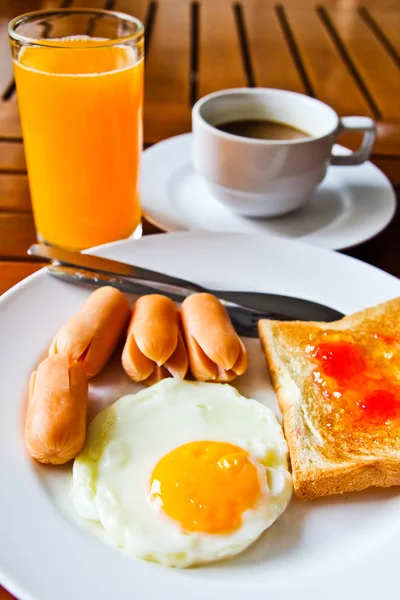 Frukost med stekt ägg, korv, rostat bröd, juice och kaffe — Stockfoto