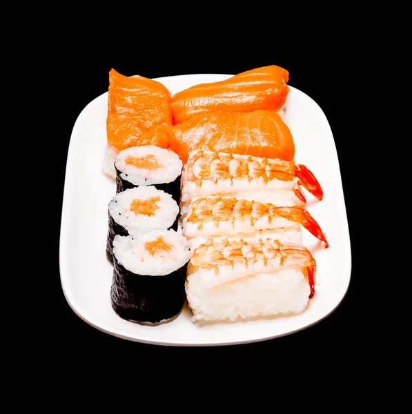 Sushi v bílé desky na černém pozadí — Stock fotografie