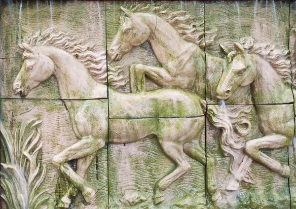 Hästar i låg relief staty utskuren som jig såg bilden och vatten f — Stockfoto