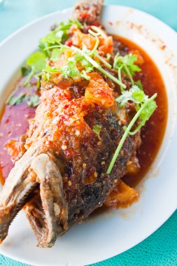 Kızarmış grouper sos, ekşi ve baharatlı beyaz tabakta Tay balık