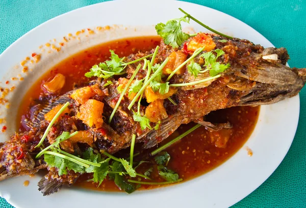 Peixe grupador frito com molho, azedo e picante no prato branco, tailandês — Fotografia de Stock