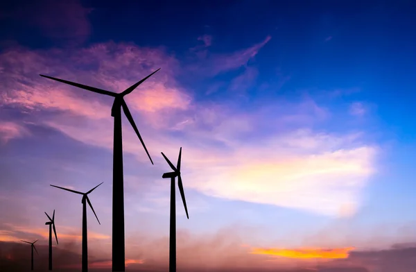 Větrná turbína silueta na barevné sunset — Stock fotografie