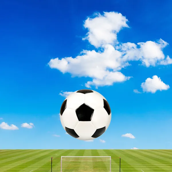 Fotbalový míč s fotbalové hřiště proti pozadí modré oblohy — Stock fotografie